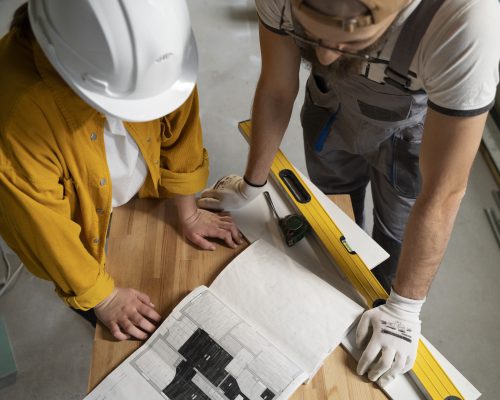 Deux artisans en action sur un plan pour effectuer la pose d'un revêtement de sol