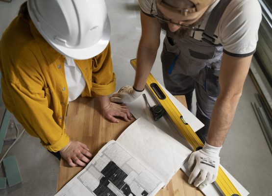Deux artisans en action sur un plan pour effectuer la pose d'un revêtement de sol